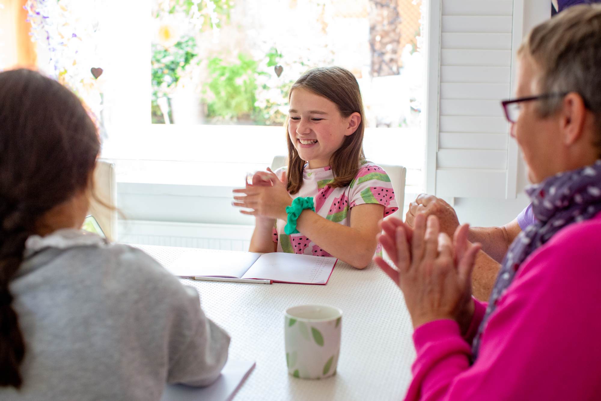 A young girl laughing and clapping her hands together