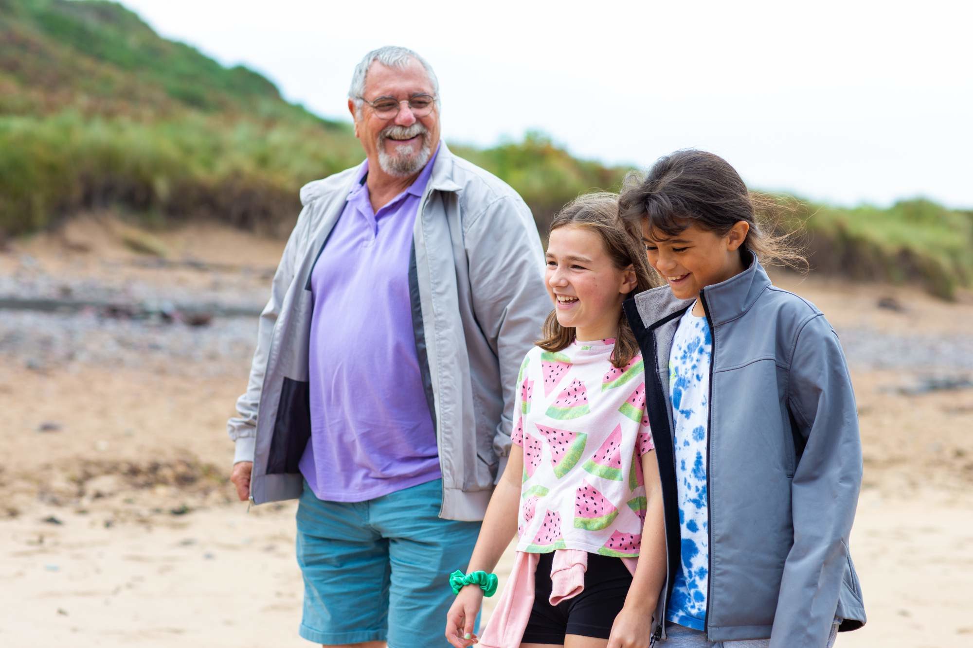 Dad and two daughters walking on the beach